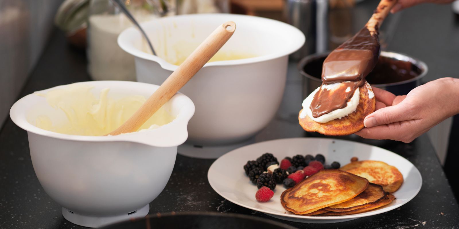 Cozy kitchen with TOLKEN countertop, VISPAD bowl set of 2, RÖRT spoon and OFTAST plate, preparing pancakes with berries.