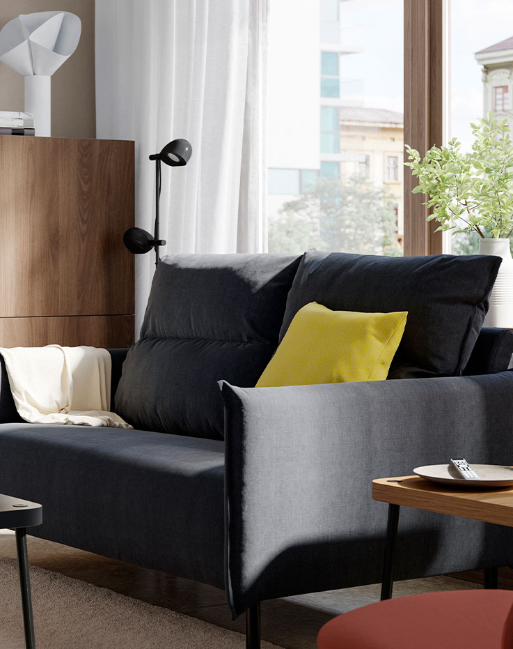 Dark furniture with a yellow cushion to create contrast.