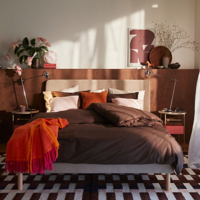 Un acogedor dormitorio con un somier tapizado TÄRNKULLEN con una funda nórdica marrón HAMPFLOCKEL y 2 fundas de almohada.