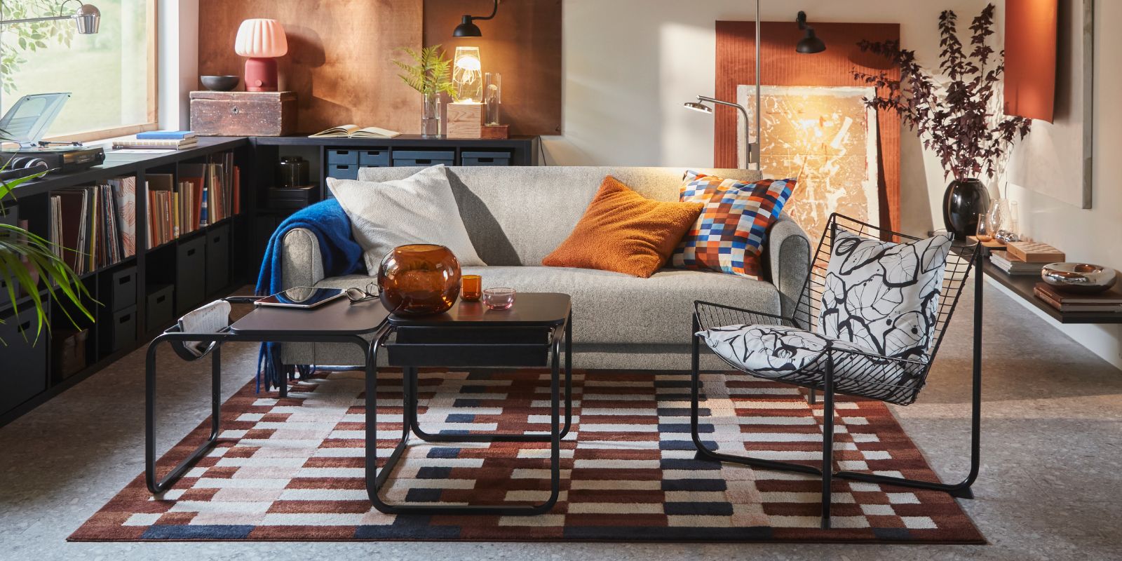 A living room features an Öreryd grey-beige SALTMYRAN 3- seat sofa placed in front of a coffee table and on a MARKBLÅMME rug.