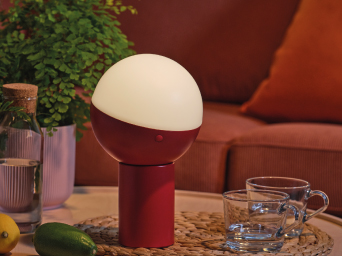 Iluminación LED, acompañado con vasos, botella de cristal y una maceta de plantas sobre una mesa