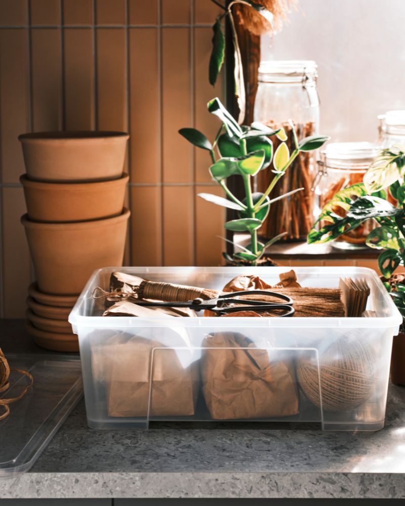 Bright garden workspace, neatly arranged with MUSKOTBLOMMA pots, SAMLA box, KORKEN jars and FEJKA plant.