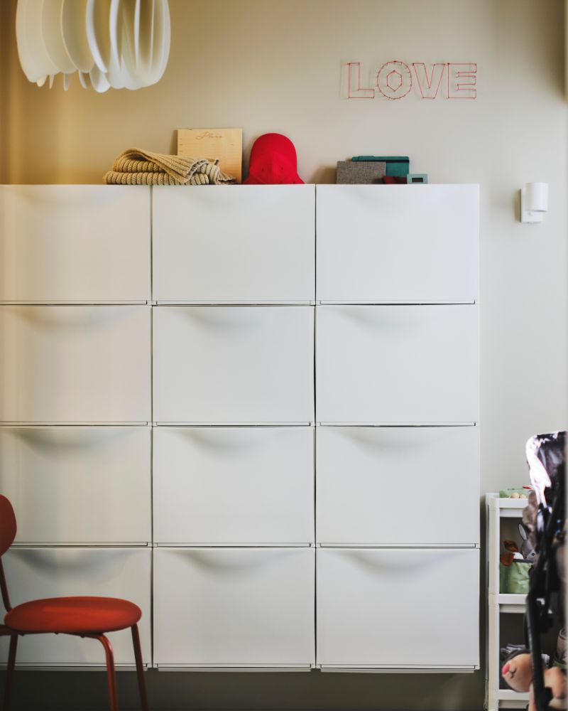 TRONES shoe cabinets create clean vertical storage, complemented by the SKYMNINGEN pendant and a LEN box on top.