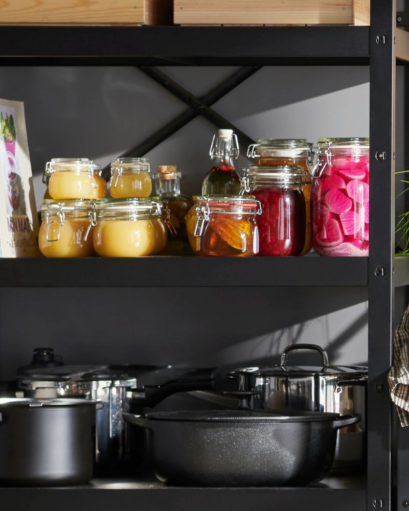 BROR shelving with KORKEN jars and IKEA 365+ and HEMLAGAD pots, forming a practical corner for preserves and cookware.