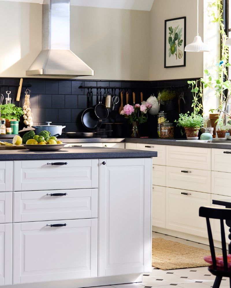 A large, traditional style kitchen with white BODBYN fronts including a kitchen island and a dining suite in dark wood.
