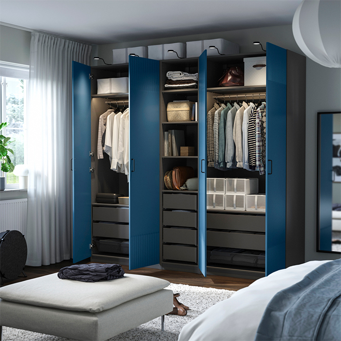Open blue wardrobe showing interior organization with hanging clothes, drawers, and storage