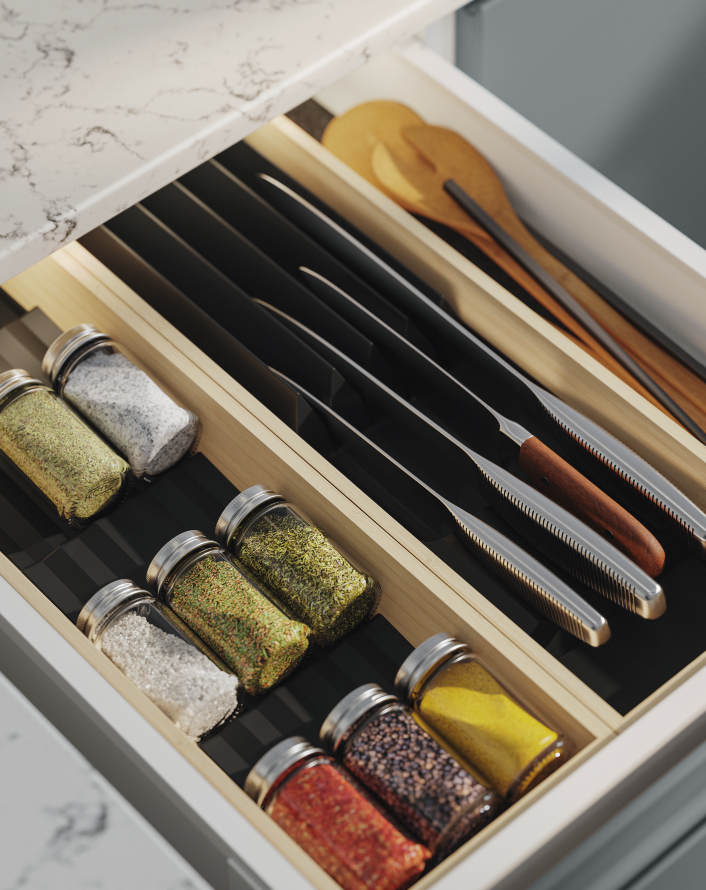 Organized kitchen drawer with knives, wooden utensils, and spice jars neatly arranged in compartments.