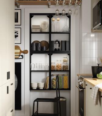 Black open kitchen shelving with jars of food, glasses, and neatly organized kitchen items.