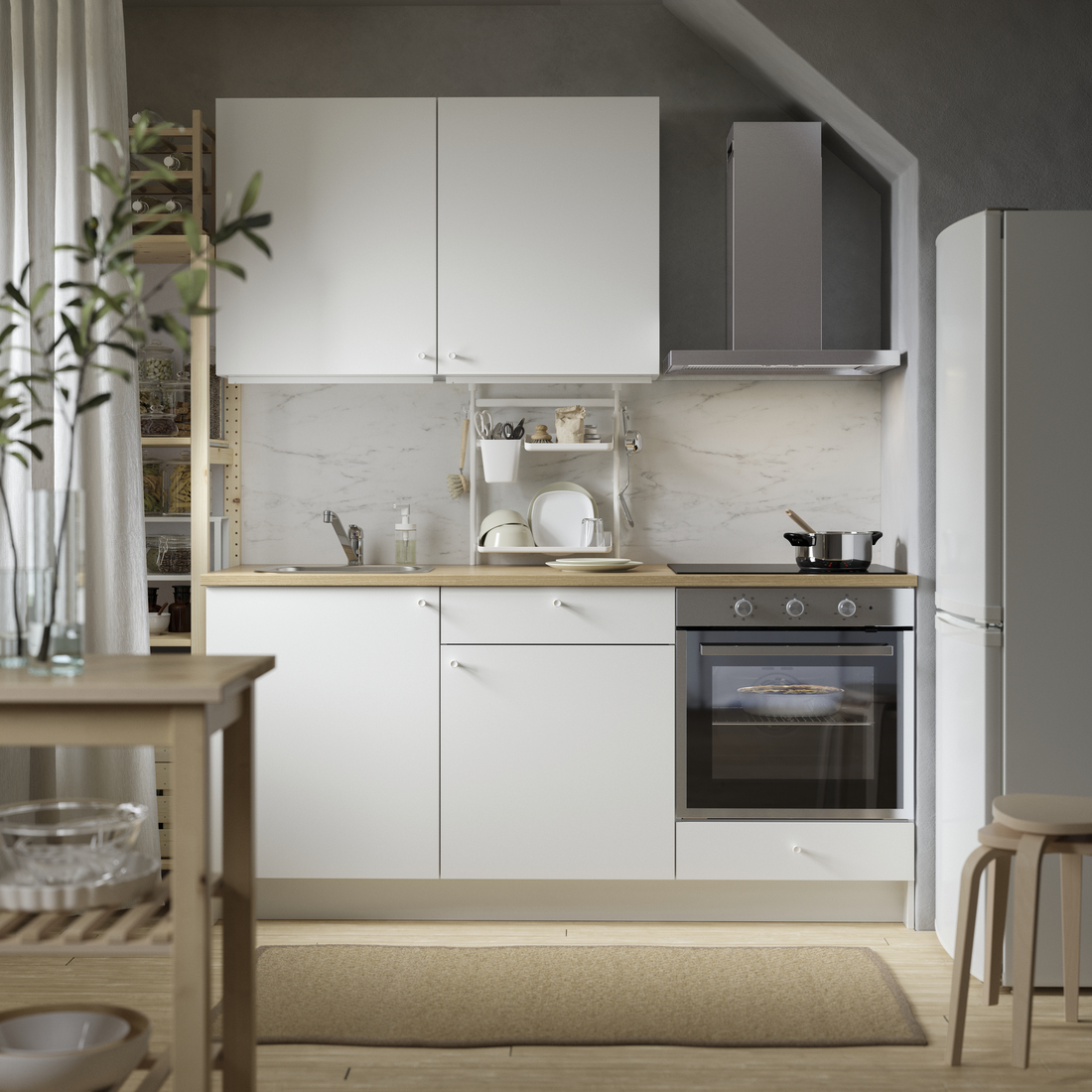 A compact modern kitchen with white cabinets, light wood countertop, and integrated appliances under a sloped ceiling.