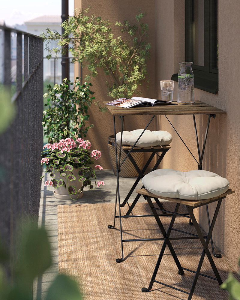 An outdoor TÄRNÖ table and chairs set with a VARDAGEN pitcher and glass, and a STRÖG rug.
