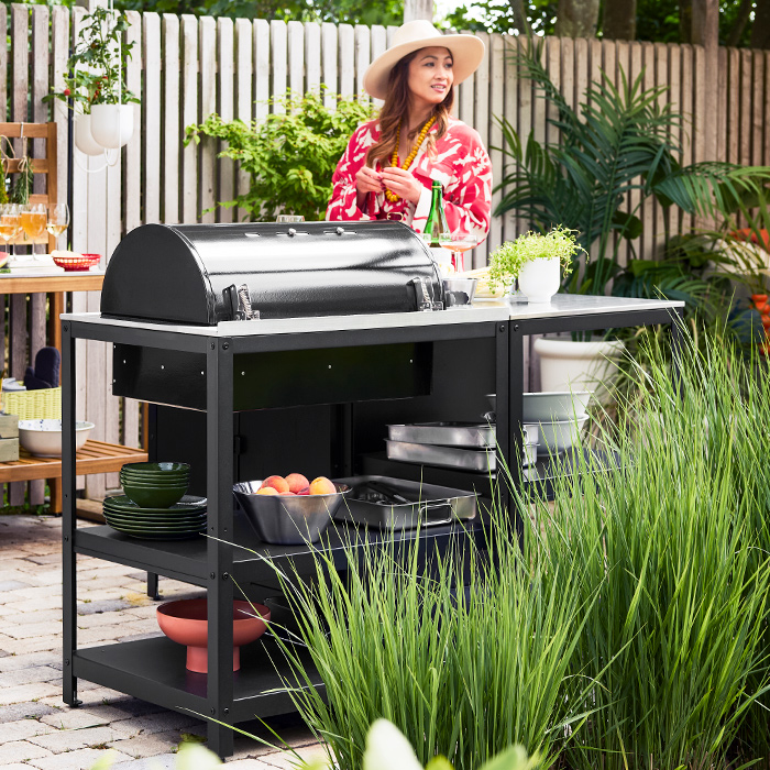 Grill unit GRILLSKÄR with PELARKAKTUS bowl, KONCIS tray, VARDAGEN bowl, and GRILLSKÄR grill cabinet, with a clumsy girl.