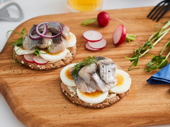 Dish of SILL DILL on an ARTISTISK cutting board.