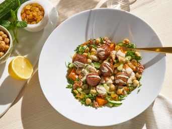 A dish prepared with HUVUDROLL meatballs on a GODMIDDAG plate and a FÖRNUFT spoon.
