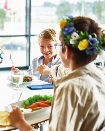 Dos personas compartiendo comida en una mesa con platos variados.