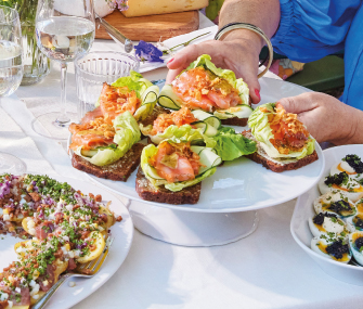 Tostadas con salmón, aguacate y ensalada servidas en platos.
