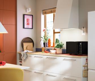 Modern white kitchen with wooden countertop and natural decor.