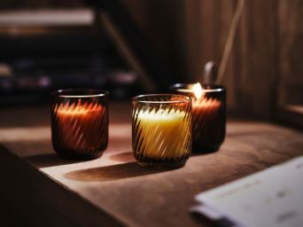 Vitrina acogedora con armario TONSTAD y velas aromáticas TÖRNFÅGEL creando una cálida iluminación ambiental.