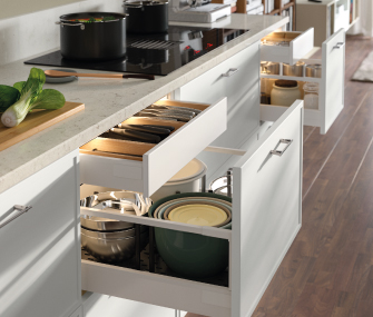 Open kitchen drawers with organized pots and utensils.