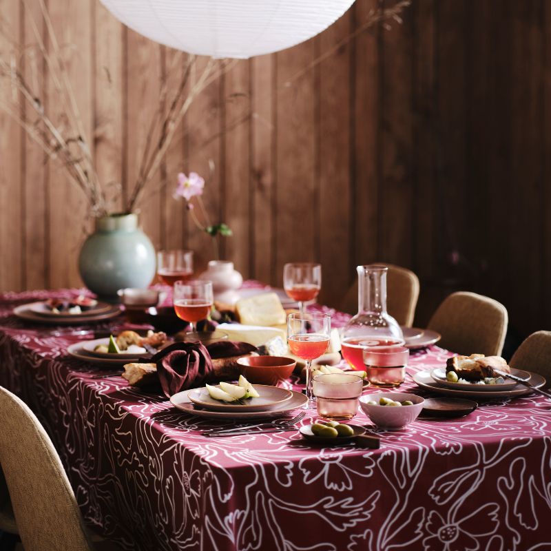 Elegant dining room with NORDMANSSKÄR chairs, FÄRGKLAR plates, OLIVTRAST serving set and GLANSGRAN vase.