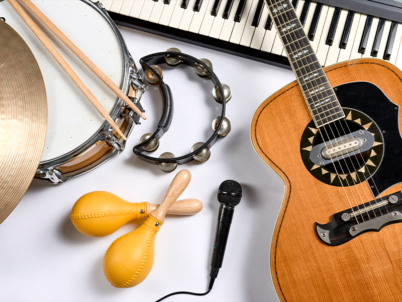 Various musical instruments, including a guitar, drum, maracas, and keyboard, on a white background.
