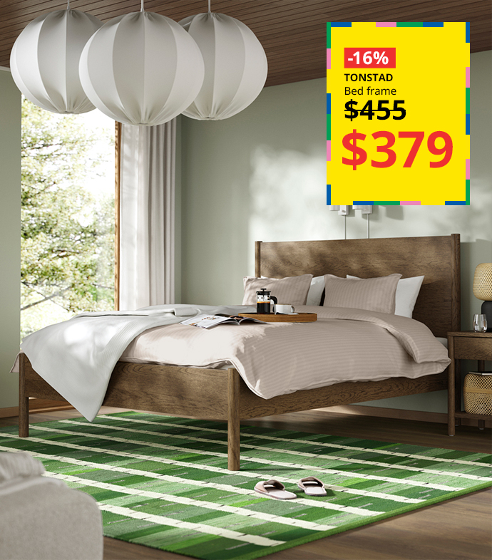 TONSTAD wooden bed frame on sale over a green striped rug.
