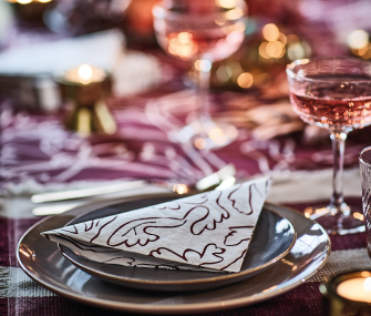 Plato con servilleta decorativa sobre una mesa elegantemente preparada.