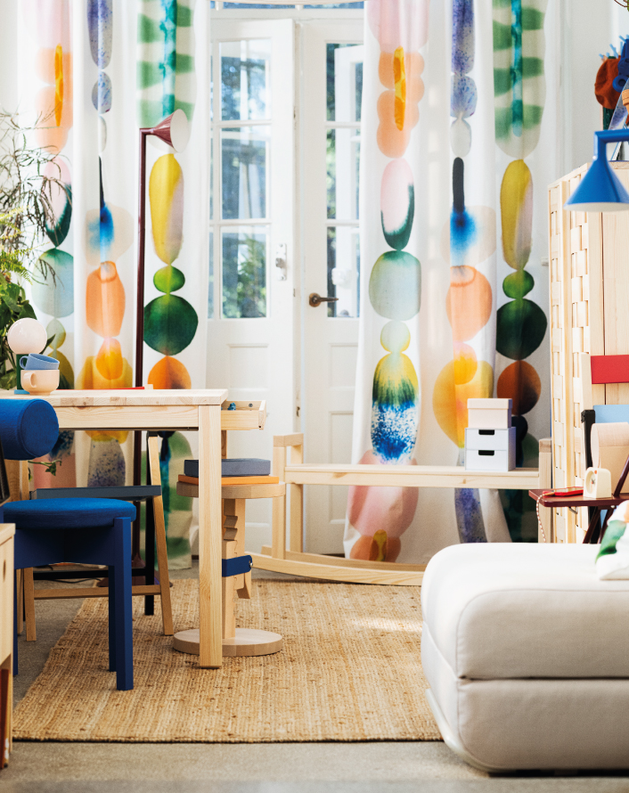 Sala luminosa con cortinas de colores y muebles de madera clara.