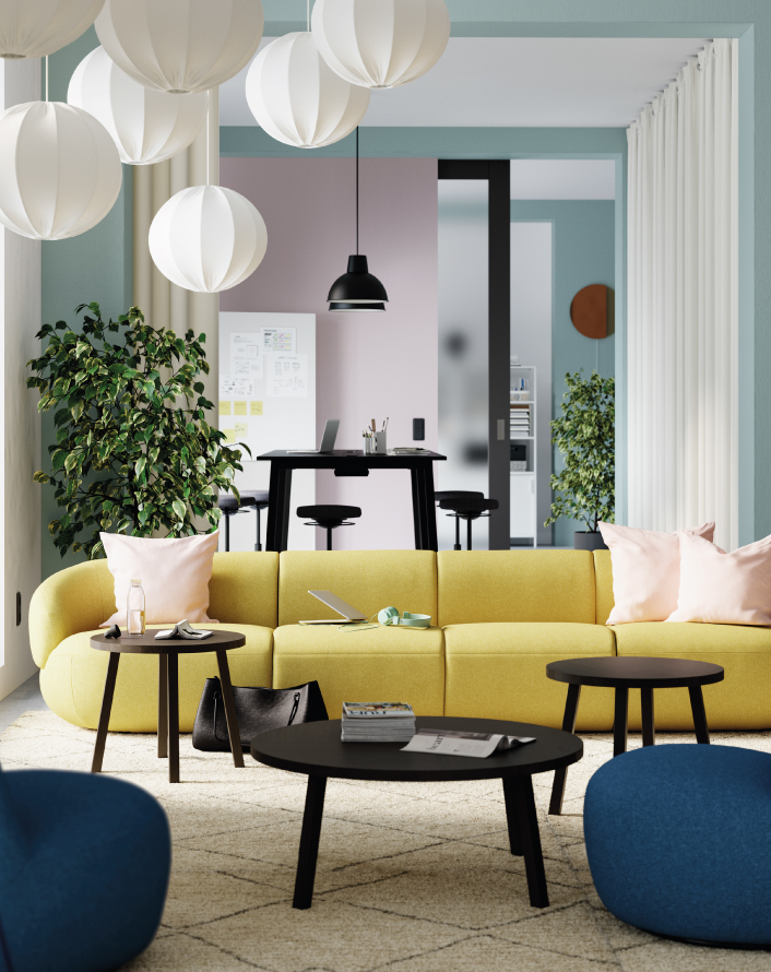 Modern living room with a yellow sofa, black tables, and white pendant lamps.