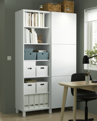 Tall white bookshelf and wardrobe unit set against a dark green wall, organized with books, boxes, and file holders.